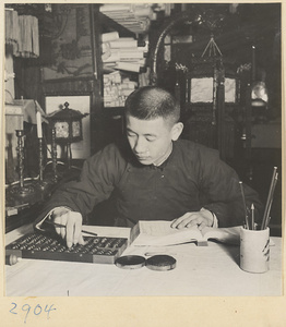Man calculating with an abacus in a lantern-making shop