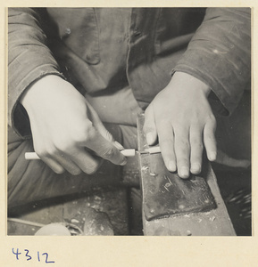 Man hollowing out a wooden brush handle in a brush-making shop