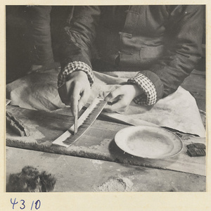 Man at work in a brush-making shop