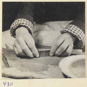 Man at work in a brush-making shop