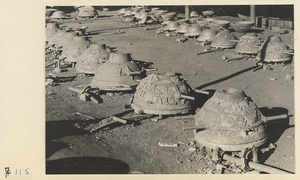 Row of iron cooking pots in molds at a foundry near Mentougou Qu