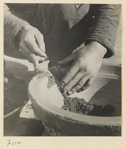 Man working on a cooking pot at a foundry near Mentougou Qu