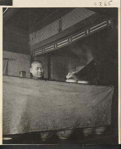 Restaurant interior showing a chef dishing food into bowls from a wok