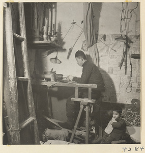 Man at work on a metal vessel in a metal-working shop