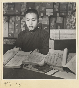 Man displaying books with side-sewn bindings in a bookshop