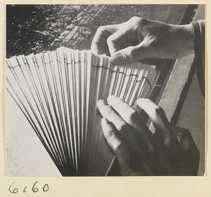 Monk assembling the pages of a new edition of a sutra in the bindery of a Buddhist temple