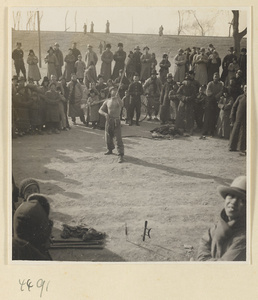 Street entertainer performing in front of a crowd at Tianqiao Market