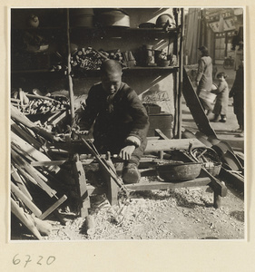 Carpenter turning a piece of wood at a lathe