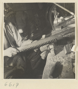 Man smoothing a comb with a plane in a horn-comb workshop