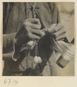 Silk spinner tying off a skein of silk