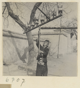 Boy spinning silk outdoors