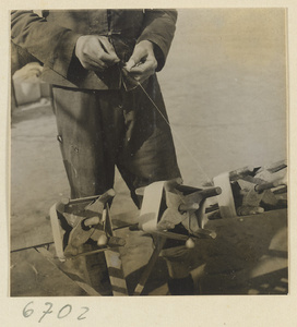 Boy spinning silk outdoors