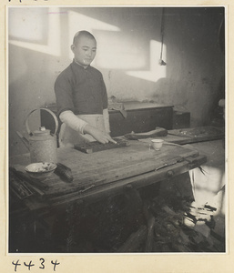 Kitchen of Niu Rou Wan, a Muslim grilled-beef restaurant, showing a worker using an abacus