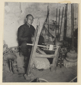 Man spinning silk in a workshop