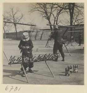 Boys setting up silk-spinning equipment outdoors