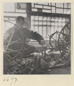 Man spinning cotton in a workshop