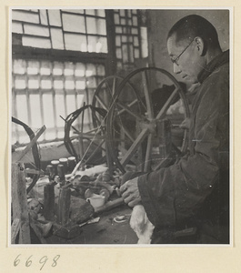 Man spinning cotton in a workshop