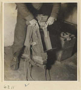 Tobacco shop interior showing a man cutting blocks of pressed tobacco