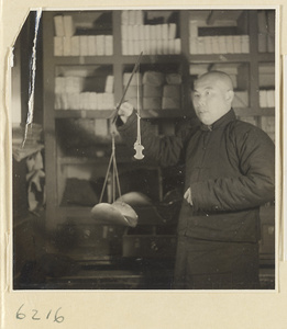 Tobacco shop interior showing a man weighing tobacco with a scale