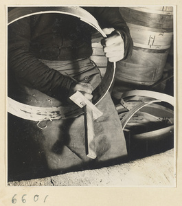 Man making a rim for a bamboo steamer in a workshop