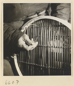 Man securing slats in a bamboo steamer in a workshop