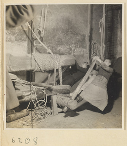 Tobacco shop interior showing a man operating a tobacco press