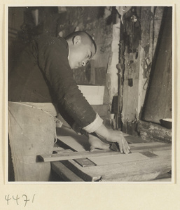 Man cutting cardboard to make a case for a book