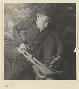 Man sawing a piece of horn in a horn-comb workshop