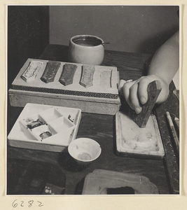 Artist grinding ink on a mortar