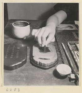 Artist grinding ink on a mortar