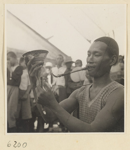 Acrobat performing a balancing act in front of a crowd at Tianqiao Market