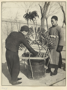 Street vendor at his food stand selling candied fruit called tang hu lu