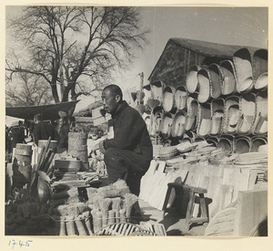 Street vendor selling brushes, baskets, and other household goods