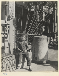 Child sitting on a crate in front of a shop