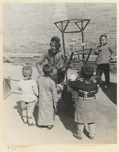 Candy vendor at his display stand watching boys eating candy