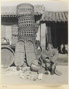 Man hawking decorative objects, beads, and jewelry in front of a basket shop