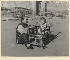 Woman sitting with a child in a baby carriage