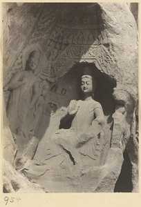 Detail of Wuzhou Cliff at Yun'gang showing cave entrance with statues of Buddha and attendants