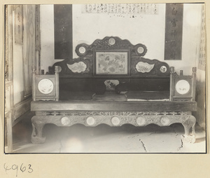 Carved wooden kang with inlays and hanging scrolls in a Daoist monastery on Hua Mountain