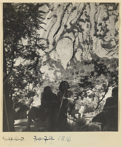 Traveler smoking a long-stemmed pipe and companions at a rest stop on the trail up Hua Mountain