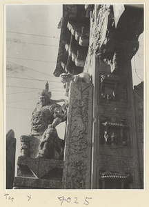 Detail of pai lou in Qufu showing guardian figure and relief panels