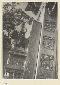 Detail of pai lou in Qufu showing a figure mounted on a lion and relief panels