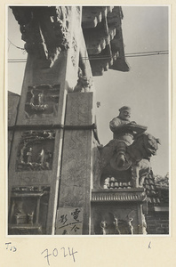 Detail of pai lou in Qufu showing a figure mounted on a lion and relief panels