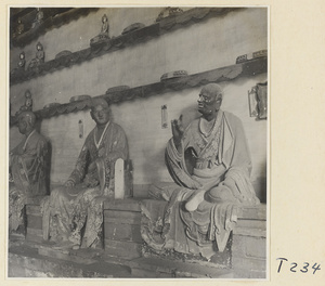 Interior of a temple building at Ling yan si showing statues of Luohans and figurines of Buddhas