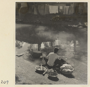 Village woman washing clothes in the river at Ji'nan