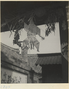 Paper figure hanging in a window on the Shandong coast