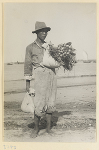 Man holding sacks of produce in a fishing village on the Shandong coast