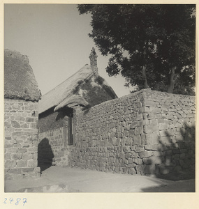 Stone and brick house with a thatched roof and stone wall in a village on the Shandong coast