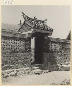 Gate and wall of stone, brick, and decorative tile in a village on the Shandong coast