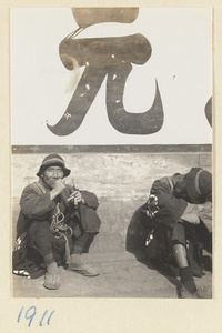 Members of a funeral procession sitting and smoking a pipe